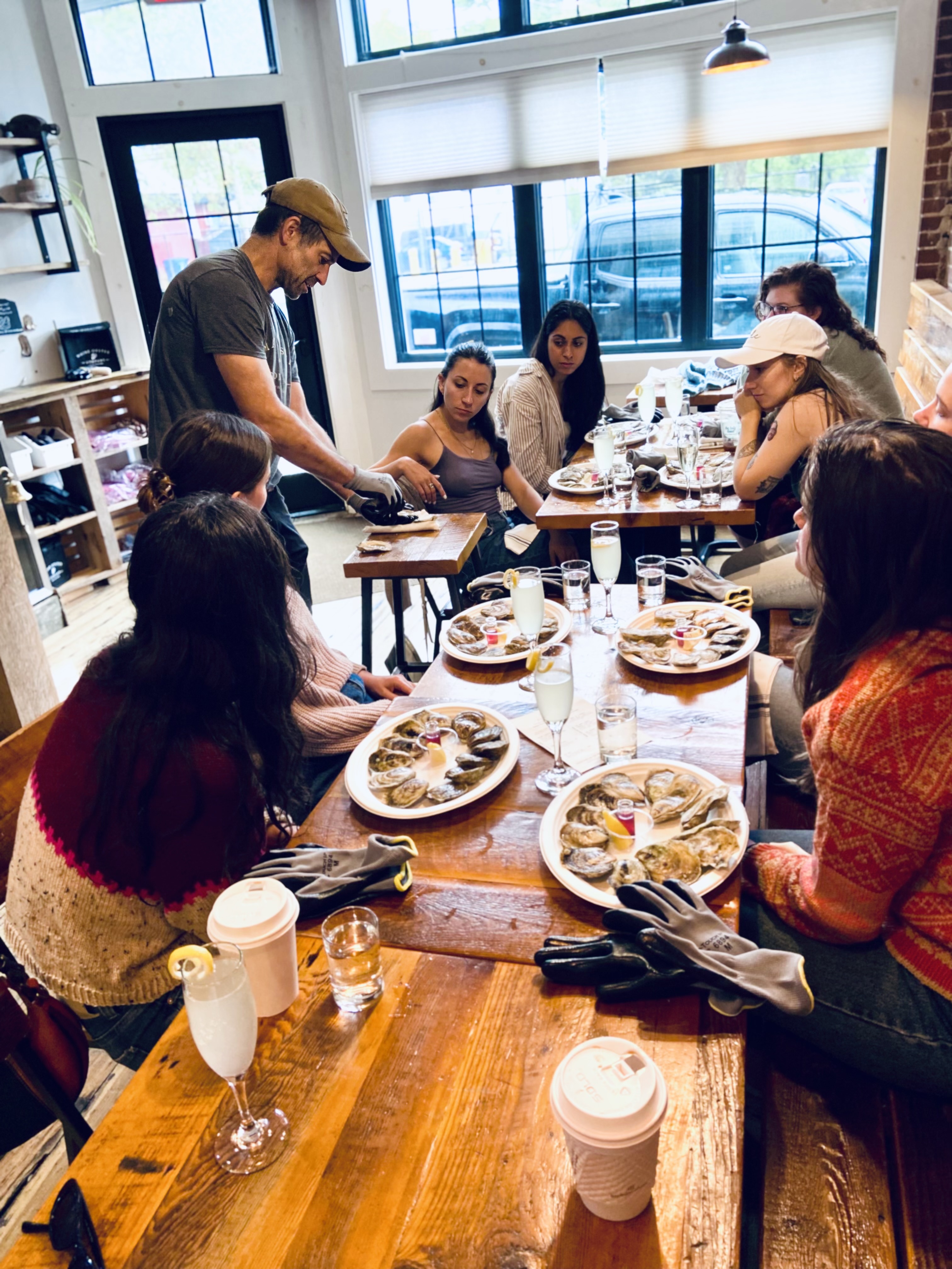 People learning to shuck at tables inside the Portland Raw Bar